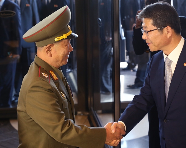 South Korean unification minister Ryoo Kihl-Jae (R) shakes hands with Hwang Pyong-So (L) vice chairman of North Korea's National Defense Commission during a a surprise visit to South Korea to attend the closing ceremony of the Asian Games