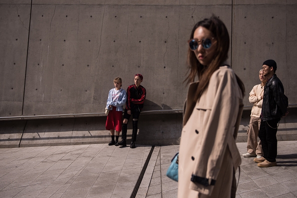 Sharply dressed South Korean fashion fans wait for a show at Seoul Fashion Week 2016.