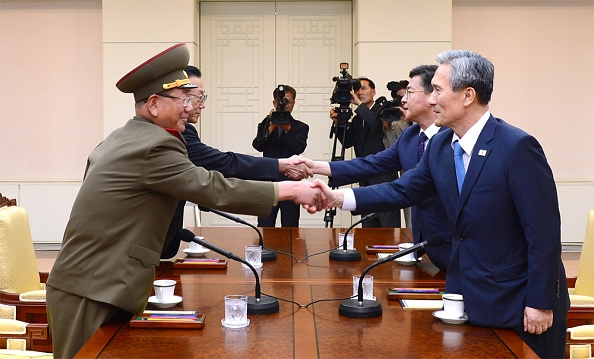 South Korean National Security Adviser Kim Kwan-Jin (R), South Korean Unification Minister Hong Yong-Pyo (2nd R), Kim Yang-Gon (2nd L), the top North Korean official in charge of inter-Korean affairs, and Hwang Pyong-So (L) the North Korean military's top political officer, shake hands during the inter-Korean high-level talks on August 22, 2015.