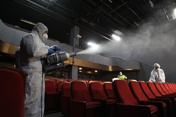 Disinfection workers wearing protective clothing spray anti-septic solution in a theater amid rising public concerns over the spread of MERS virus